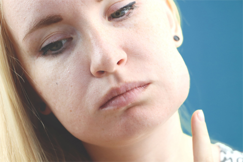 mujer con flemon y gesto de dolor